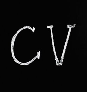 Chalk text 'CV' on a black chalkboard. Ideal for resume or education-related themes.